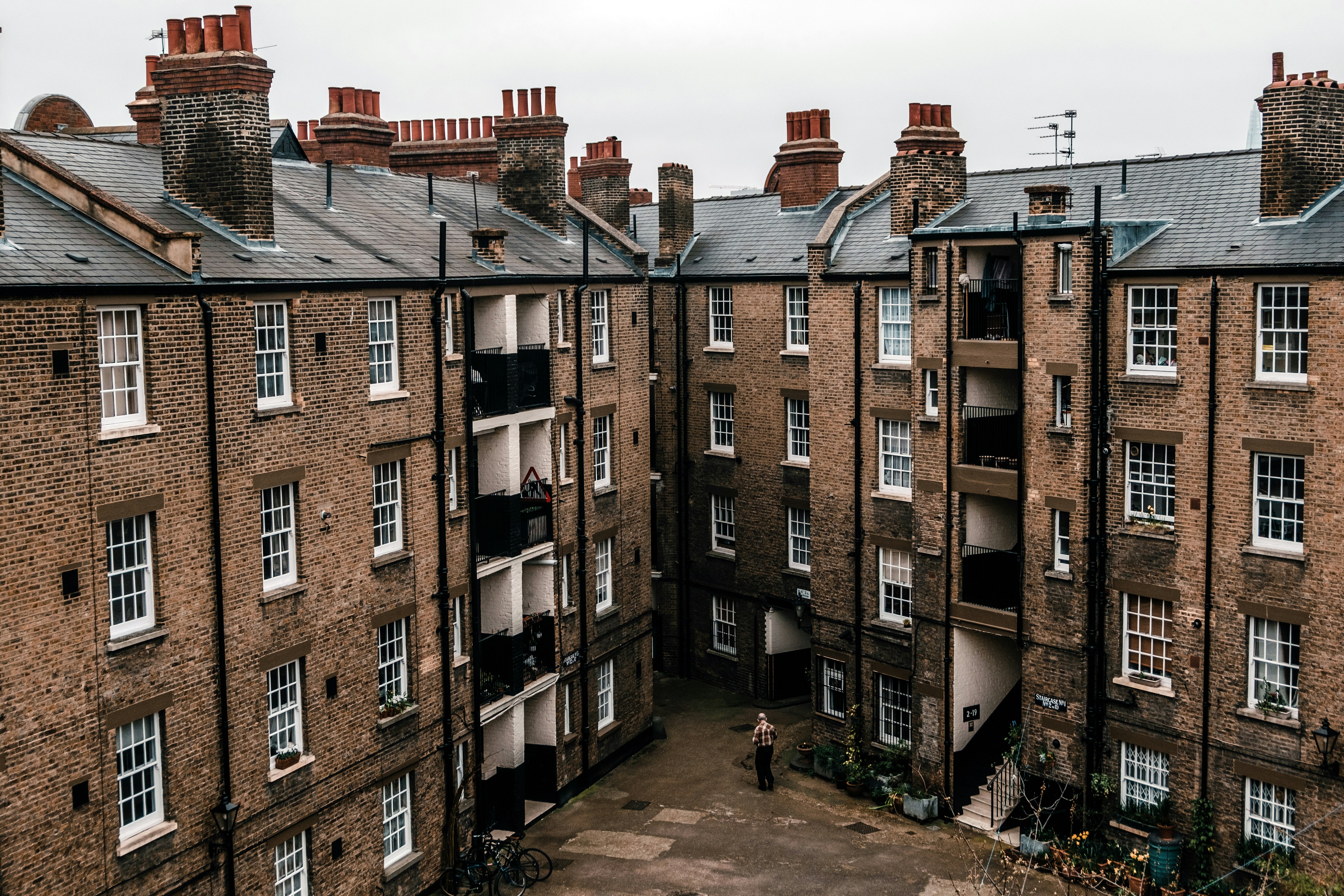 person standing near brown buildings during daytime